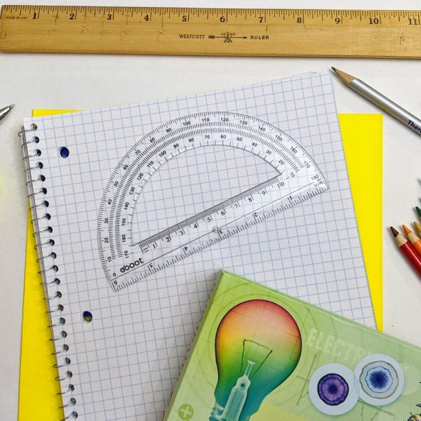 green and yellow scissors on white graphing paper